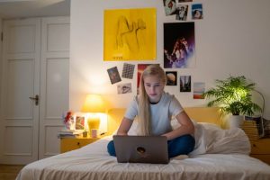a girl playing her laptop on bed - Darren Yaw Cambodia: Tips to Handle Teenagers